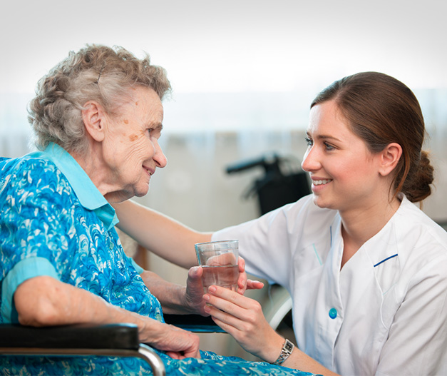 A female care assistant laughing with an elderly woman